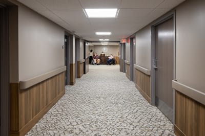 Interior hallway with residents and staff visible