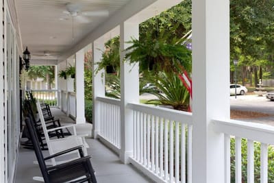 Covered porch with rocking chairs and greenery