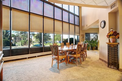 Bright dining room with large windows and wooden furniture