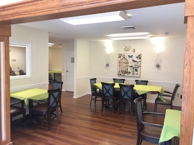 Dining room with green tablecloths and wooden chairs