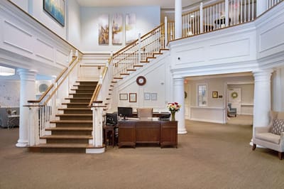 Bright interior lobby with a staircase and reception desk