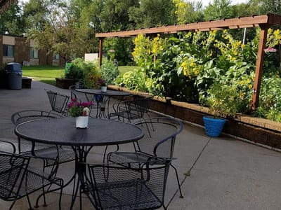 Outdoor seating area with tables and greenery