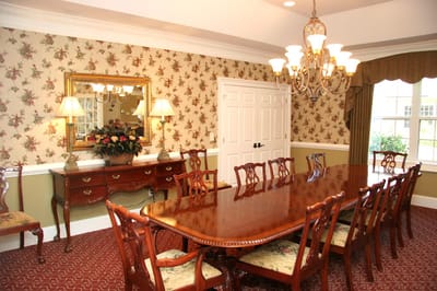 Elegant dining room with a large wooden table and floral wallpaper