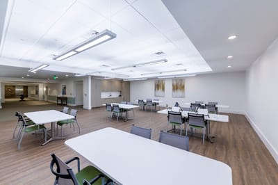 Bright and spacious common area with tables and chairs