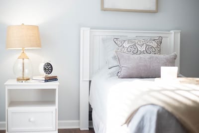 Cozy resident room with bedside lamp and decorative pillows