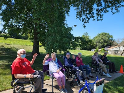 Residents enjoying time outdoors and waving