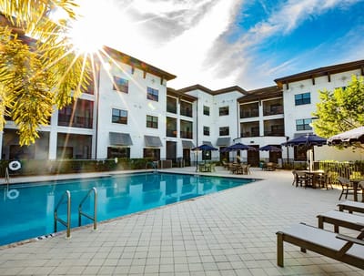 Outdoor pool area with sun loungers and umbrellas