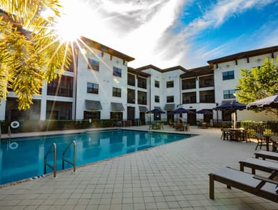 View of a sunny outdoor pool area with lounge chairs