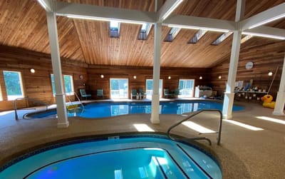 Indoor pool area with wooden ceiling and natural light