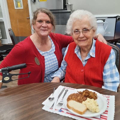 Resident and staff sharing a meal together