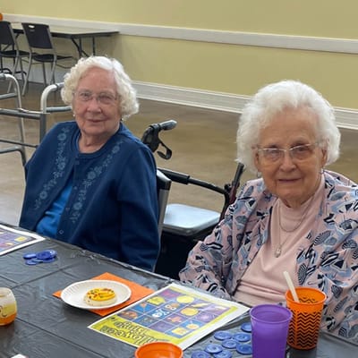 Two residents smiling while playing bingo