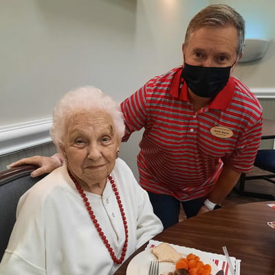 Resident enjoying a meal with staff member