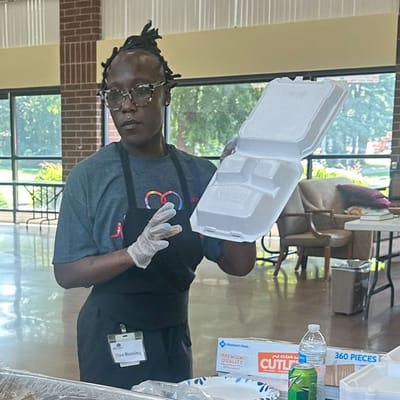 Staff member displaying a food container in a common area