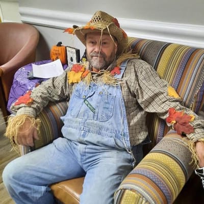 Resident dressed as a scarecrow for a festive celebration