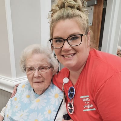 Staff member poses with a resident in a common area