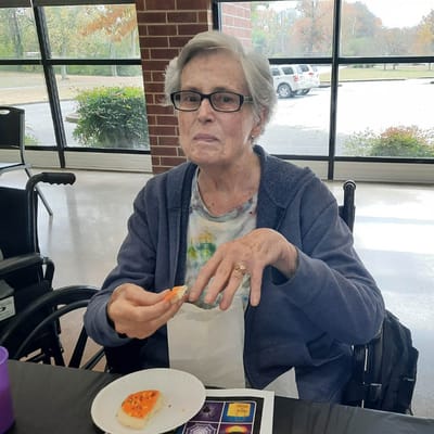 A resident enjoying a snack during an activity