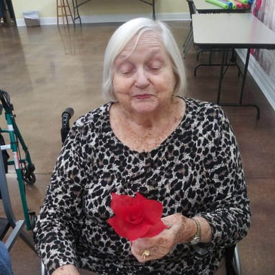 Resident holding a red flower in a common area