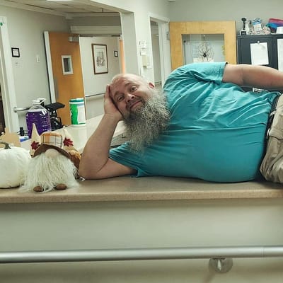 A resident smiling while lying on a countertop