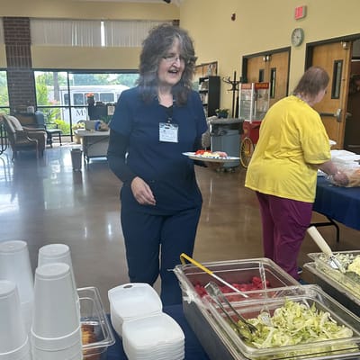 Staff serving food in a dining area with residents