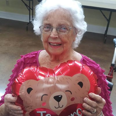 Elderly woman holding a heart-shaped balloon