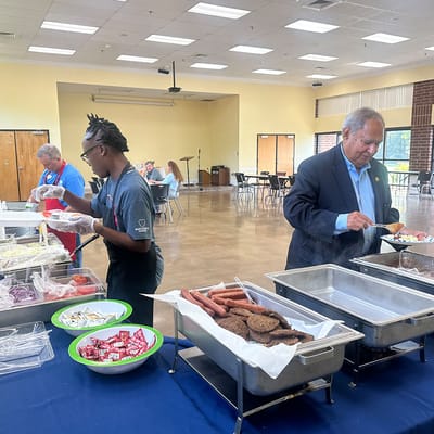 Staff serving food in a dining area during a community event
