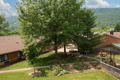 Outdoor view of the facility grounds with trees and seating areas