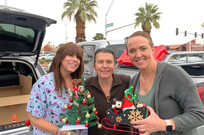 Three staff members celebrating with holiday decorations