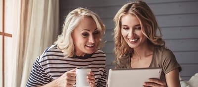 Two women sharing a joyful moment over a tablet