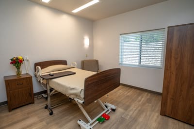 Private resident room with a hospital bed and seating area
