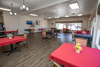 Bright dining room with red tables and flowers