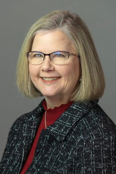 Professional portrait of a smiling woman in a blazer