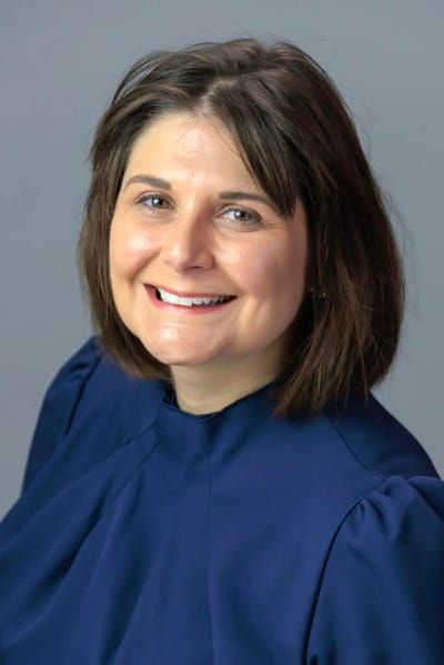 Smiling staff member wearing a navy blue dress