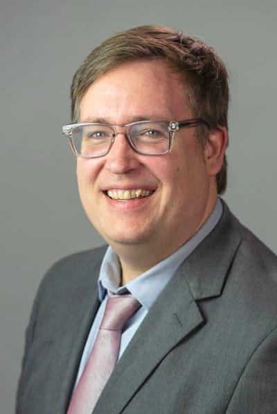Portrait of a man in a suit with glasses