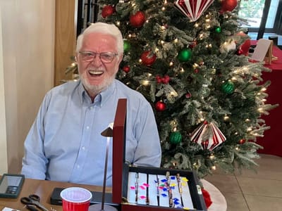 Resident smiling by a decorated Christmas tree