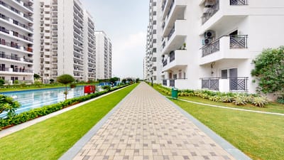 Pathway with greenery and buildings near a pool