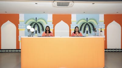 Reception area with two staff members in orange outfits