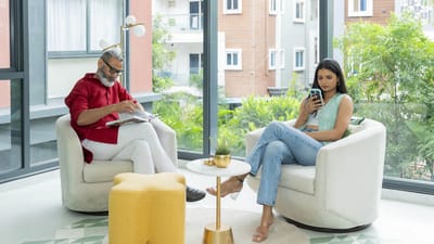 Residents in a bright common area engaged in leisure activities.