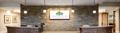 Welcoming reception area with stone wall and facility logo