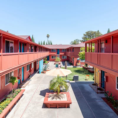 View of a courtyard with green space and colorful buildings