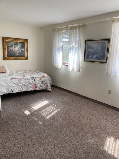 A private resident room with a bed and artwork