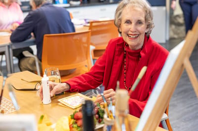 Happy resident enjoying time with friends at a dining table