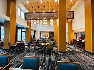Common area with brown and blue seating and a bright chandelier