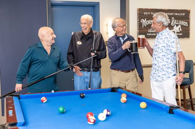 Residents enjoying a pool game in an activity room