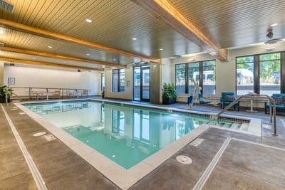 Indoor swimming pool area with lounge chairs