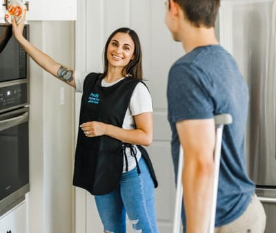 Staff member assisting a resident in a kitchen