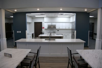 Modern kitchen area with white cabinets and countertops