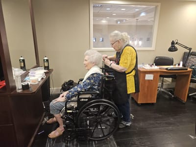 Senior resident receiving a hair treatment in a salon