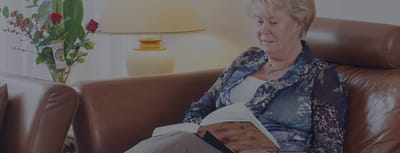 Senior resident reading a book in a cozy lounge