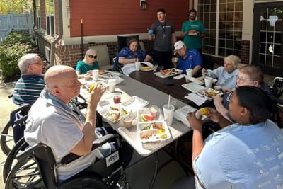 Residents enjoying lunch together outside on a patio