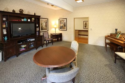 Common area with a table and chairs in a senior facility